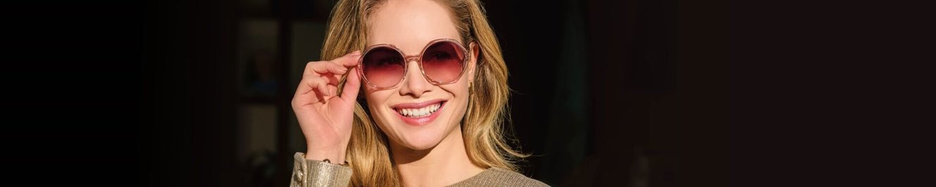 Vrouw met ronde zonnebril glimlacht