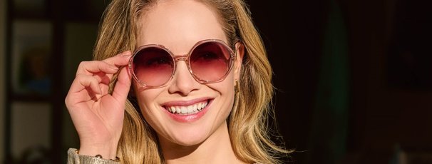 Vrouw met ronde zonnebril glimlacht