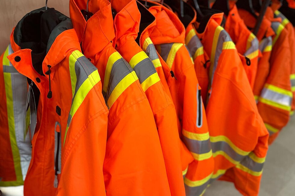 New high-vis safety coats hung in store.