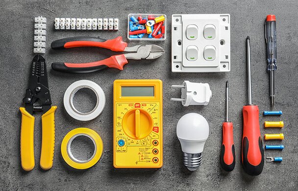 Group of electrical products on a grey background.