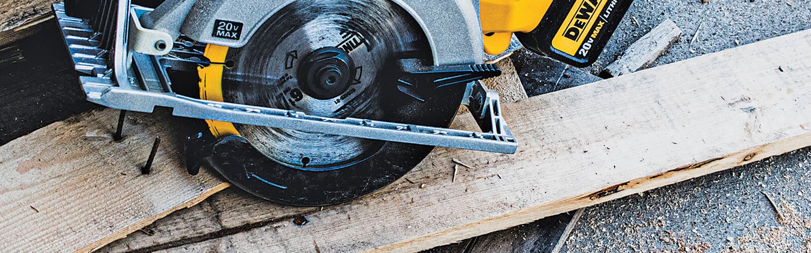A DeWalt circular saw is sitting on a piece of rough lumber. 