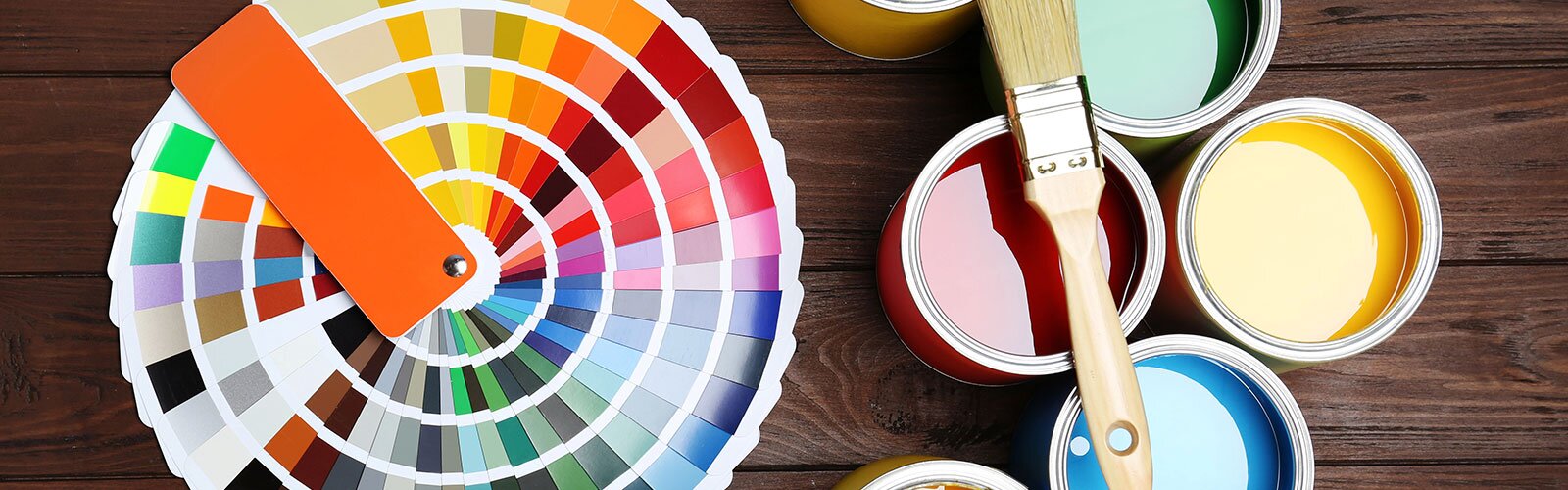 Open paint cans beside a rainbow of paint swatches, fanned out. 