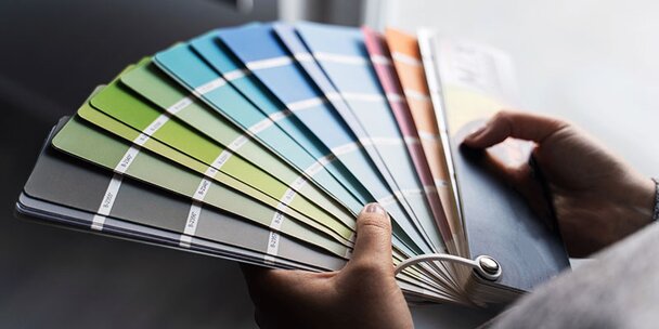 Up close on the hands of a person holding a colour palette at home.