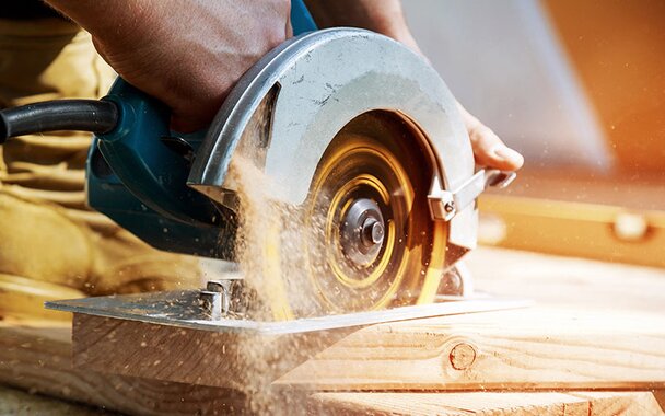 A circular saw is cutting a piece of lumber.