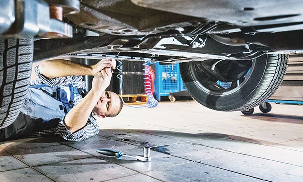 A mechanic working under a vehicle.