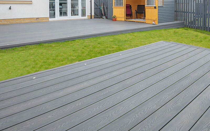 A home's backyard with a freshly installed grey composite decking.