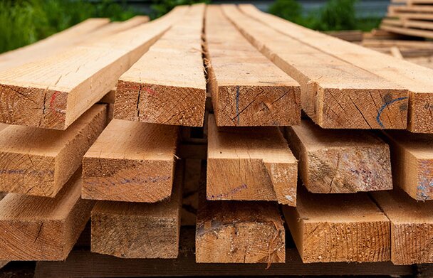 Lumber stacked outside in a lumber yard.