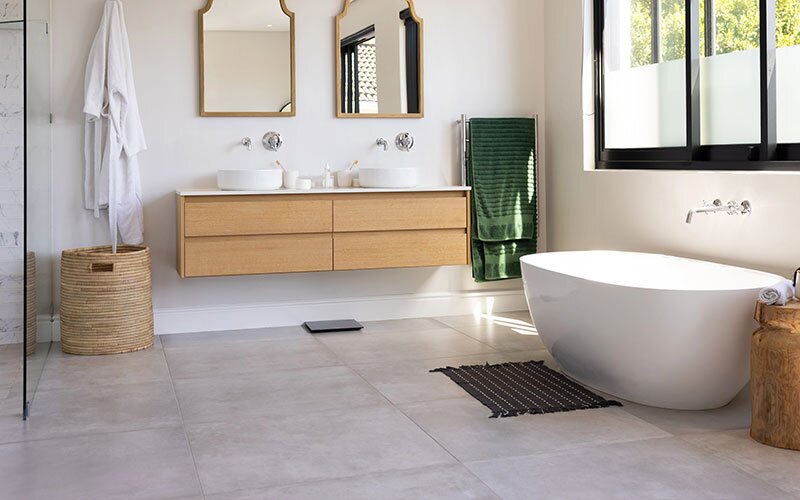 A modern and fresh bathroom with tile floor and natural light.