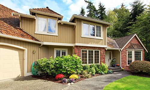 Beautiful 90's style home with a well-landscaped front.