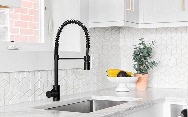Black pull-down faucet and a stainless steel undermount sink. 