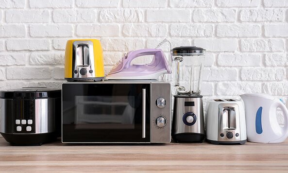Collection of small appliances on a wooden butcher's block.