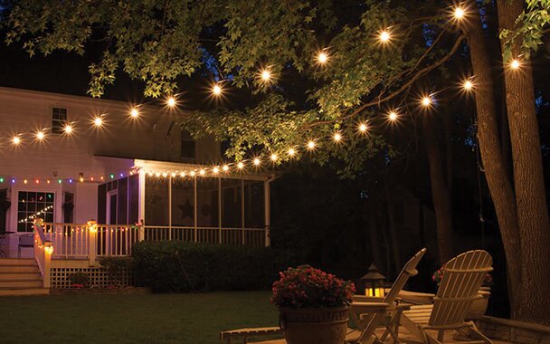 A backyard lit up by a string of lights