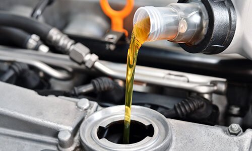 New oil is being poured into the car engine.