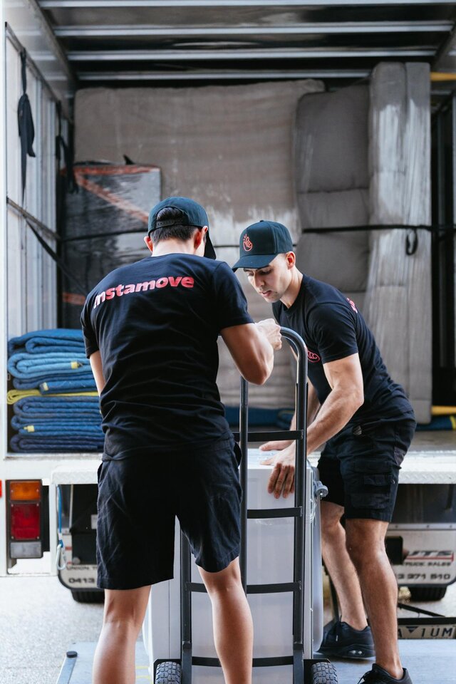 Portrait of an Instamove staff member standing in the back of a truck among packed household items during loading