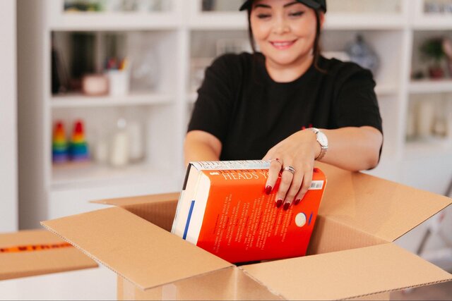Instamove mover reviewing a clipboard of items with a couple beside a branded moving truck during morning briefing
