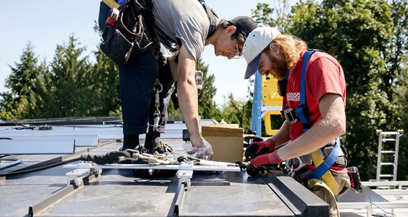 two men working on rooftop solar panel 