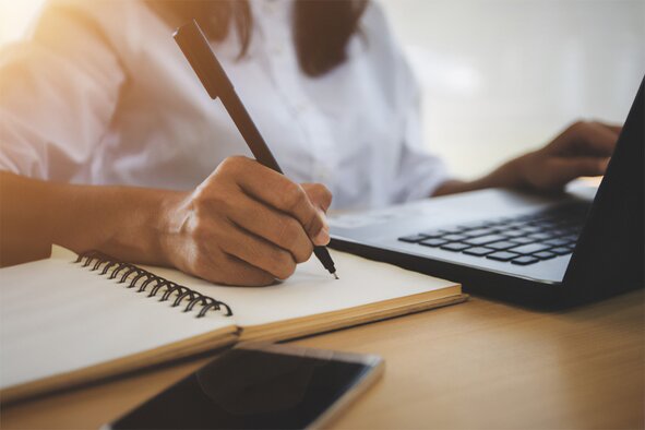 Person taking notes for resources