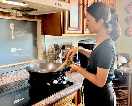 Chef Grace Zhou cooking with a wok on her induction cooktop.