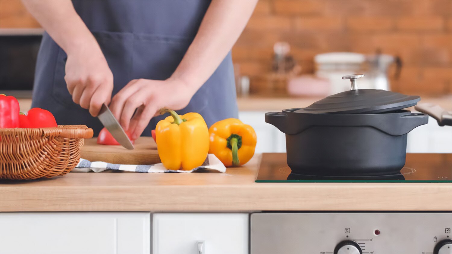 Person cutting vegetables near induction cooktop