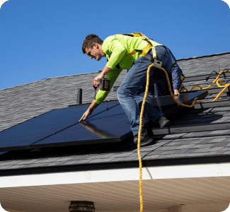 Contractor fixing solar panel on home rooftop