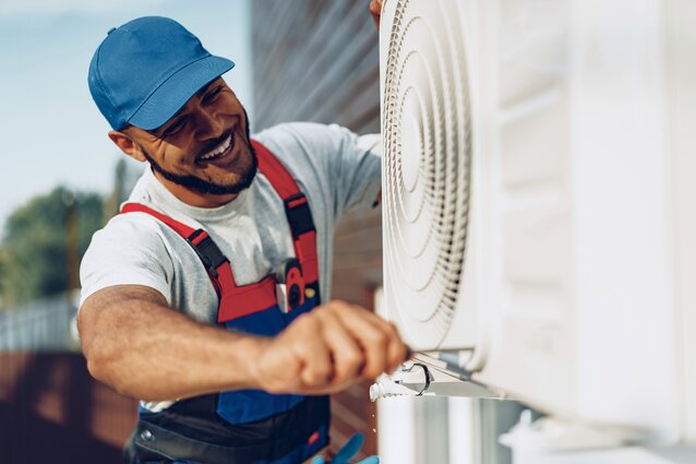 Happy contractor fixing Heat pump unit