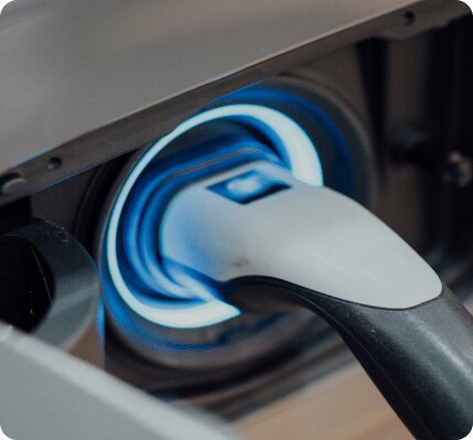 Closeup of electric vehicle charger connected to vehicle