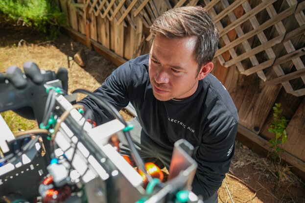 Contractor working on exterior appliance