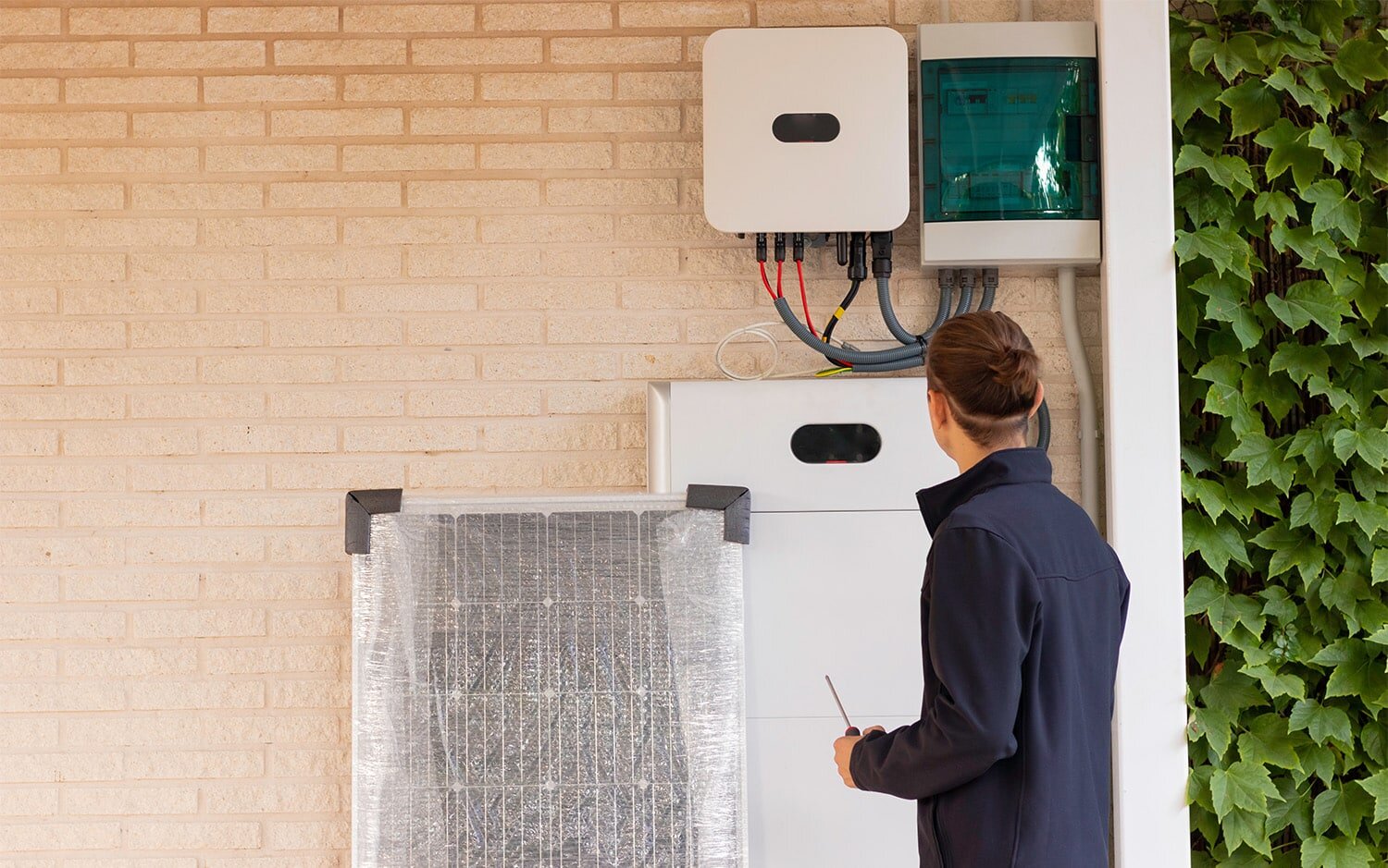 Contractor setting up a batter storage unit on home wall