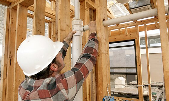 Plumber installing pipes