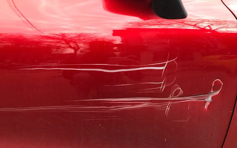 Vista detalhada de carro sendo reparado para riscos em portas