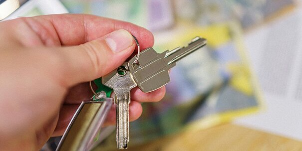 An upclose capture of hands holding keys in fingers.
