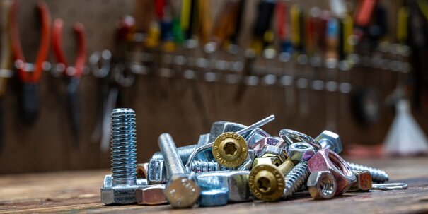 A pile of Midwest Products (nuts, bolts, fasteners) on a workbench.