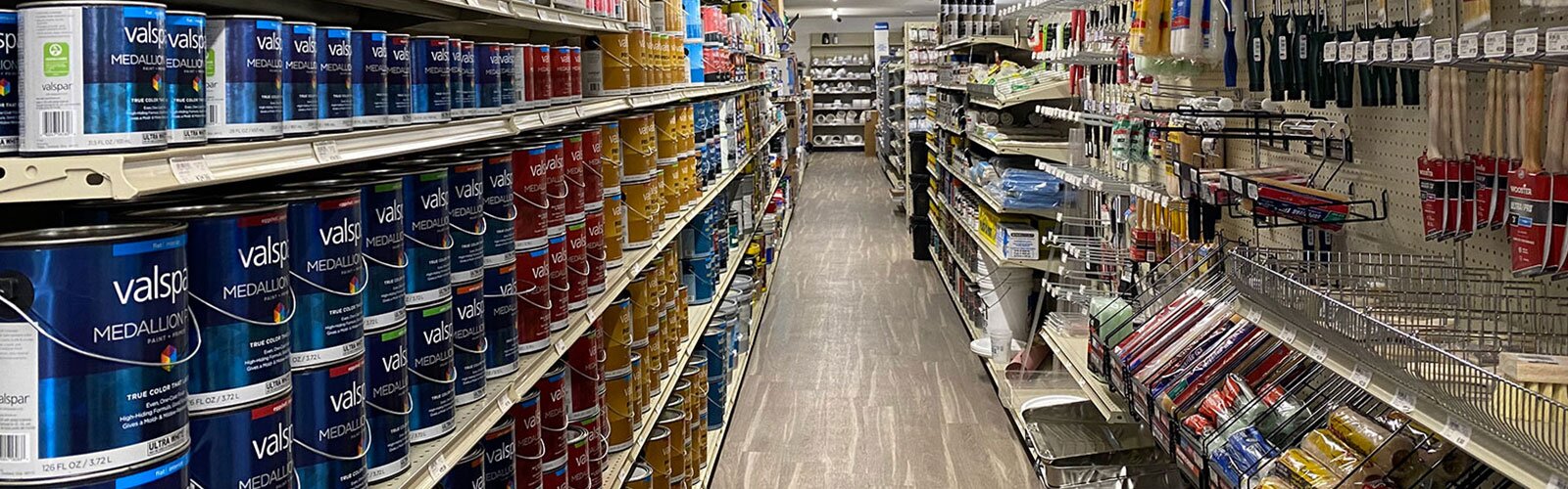 Paint aisle showing a variety of products, including paint cans and brushes at HomeTown Solutions.