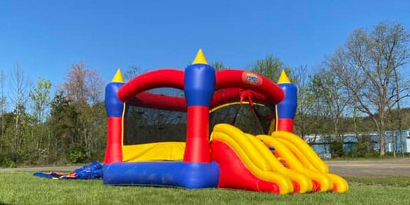 A bouncy castle with a slide for birthday parties or events.