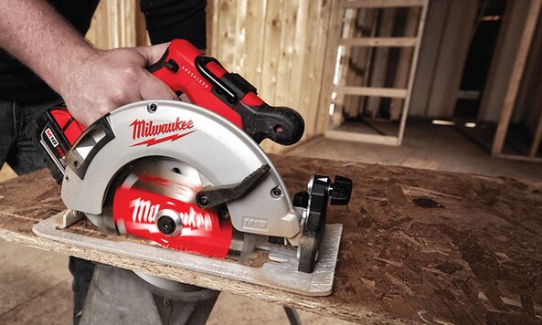 A Milwaukee cordless circular saw is being used to cut lumber.
