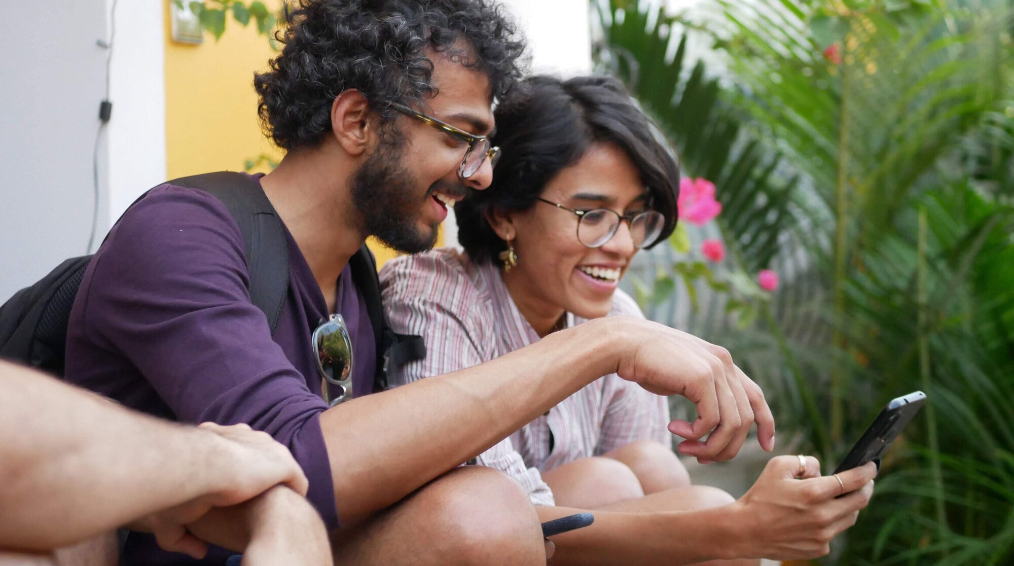 man and woman smiling and looking at a phone
