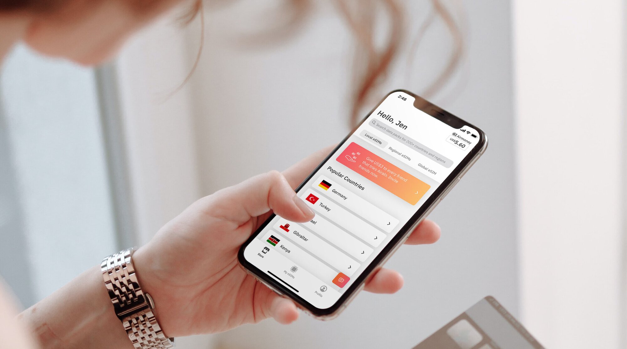 woman looking at Airalo eSIM app on her smartphone