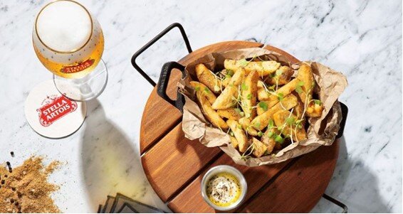 Image of Garnished Fries with dip and
        a glass of Stella Artois