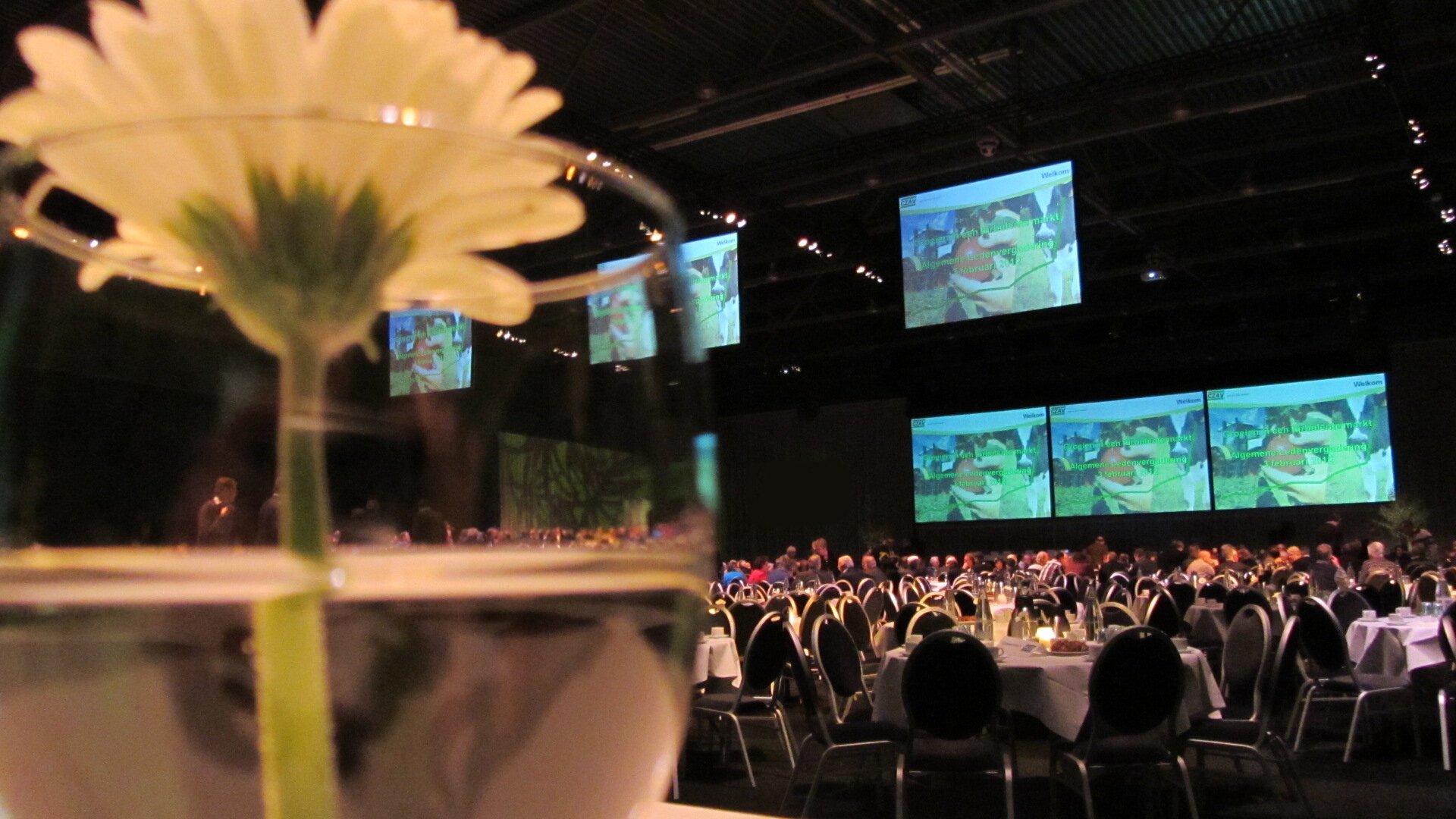 Professionele AV-opstelling in conferentiezaal met meerdere schermen en professionele apparatuur