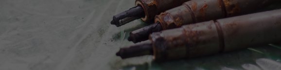 Three rusted fuel injectors laying next to each other