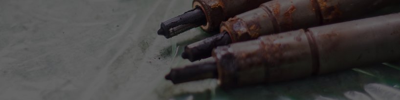 The tips of three corroded diesel fuel injectors laying next to each other