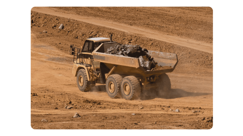 An articulated truck carrying materials through dirt