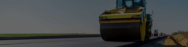 A drum roller paving a road