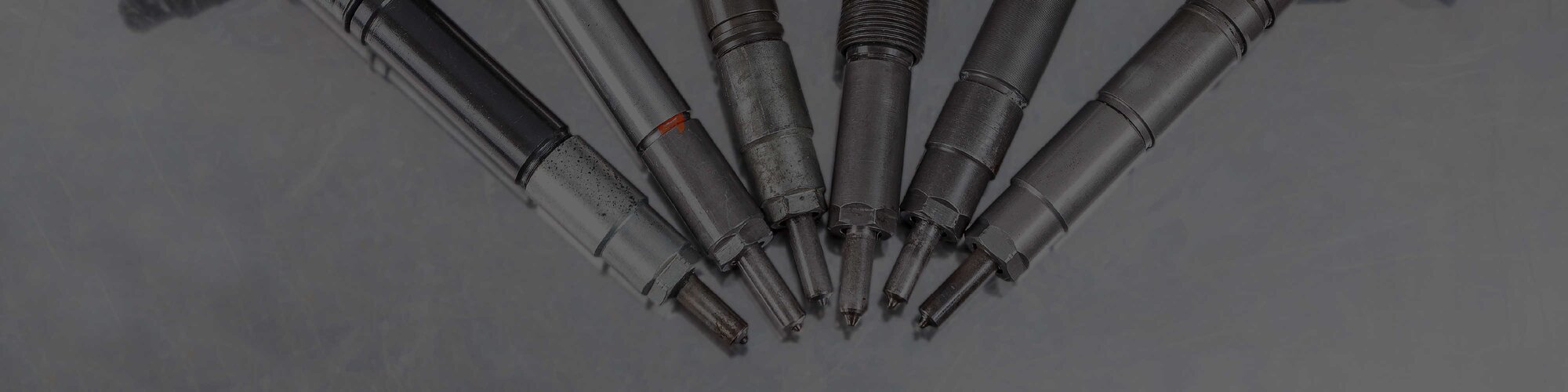 6 shiny diesel fuel injectors arranged in a semicircle