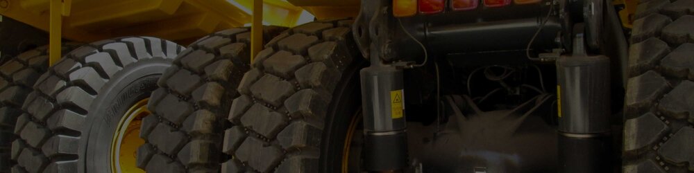A close up of the suspension system of a large, wheeled machine