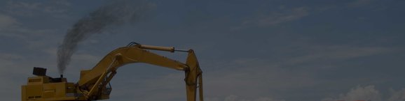 Smoke exiting the top of a yellow excavator