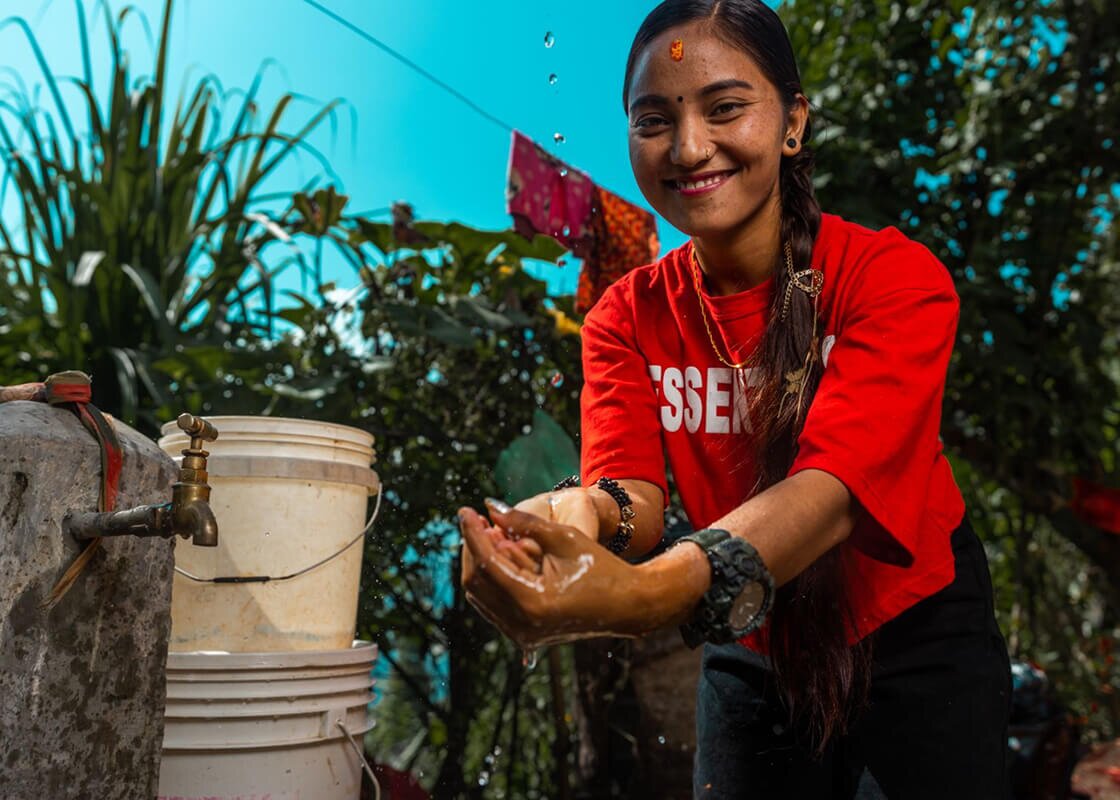 Woman washing hands with clean, safe water at a tap