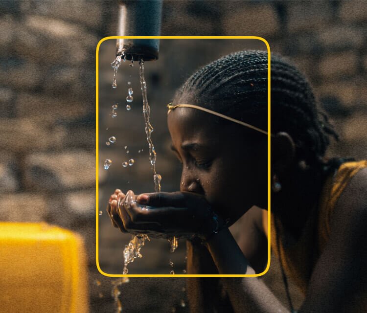 African girl filling her hands with clean, safe water and taking a drink