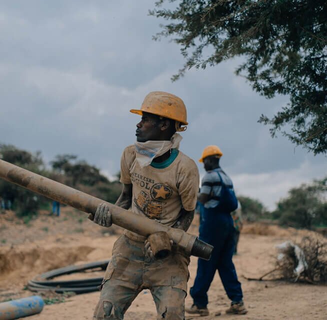 African man building a water access point