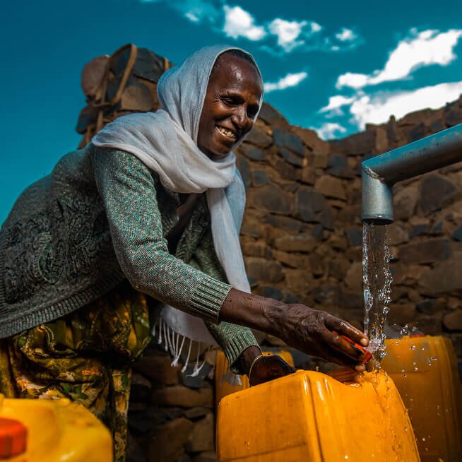 African woman filling a jerry can with clean, safe water